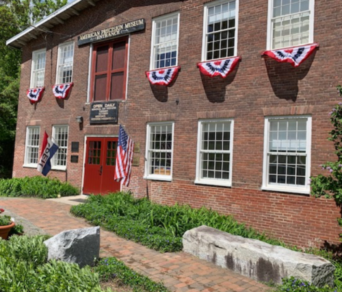 Exterior of the American Freedom Museum, featuring red, white, and blue bunting and American flags.