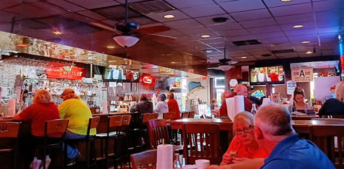 A lively bar scene with patrons at the counter, neon signs, and a warm, inviting atmosphere.