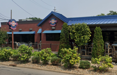 Exterior of Ferris restaurant featuring a blue roof, brick walls, and greenery along the sidewalk.