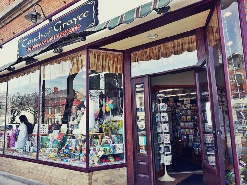 A storefront with a sign reading "Touch of Grayce," featuring colorful displays and various goods in the window.