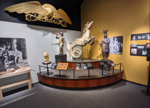 Exhibit featuring ancient sculptures, artifacts, and informational displays in a museum setting.