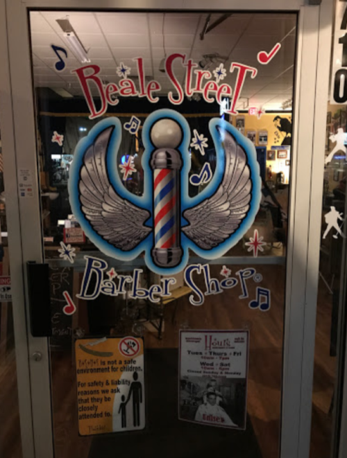 A colorful sign on a barber shop door featuring a barber pole with wings and musical notes.