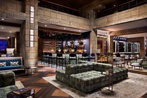 Stylish lounge with modern seating, a bar area, and decorative walls, creating a sophisticated atmosphere.