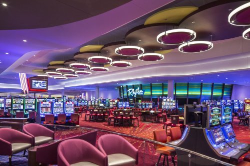A vibrant casino interior featuring slot machines, gaming tables, and modern lighting.