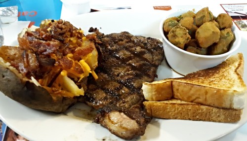 A plate featuring a grilled steak, loaded baked potato with bacon, fried okra, and two slices of toast.