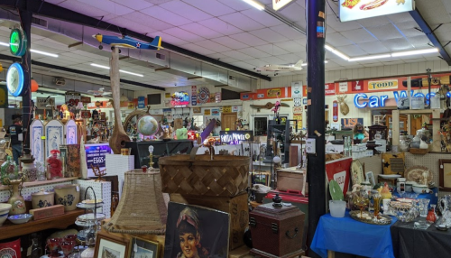 A vibrant antique shop filled with various collectibles, vintage signs, and decorative items.