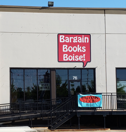 Exterior of Bargain Books Boise store with a large sign and a banner, featuring a ramp and windows.