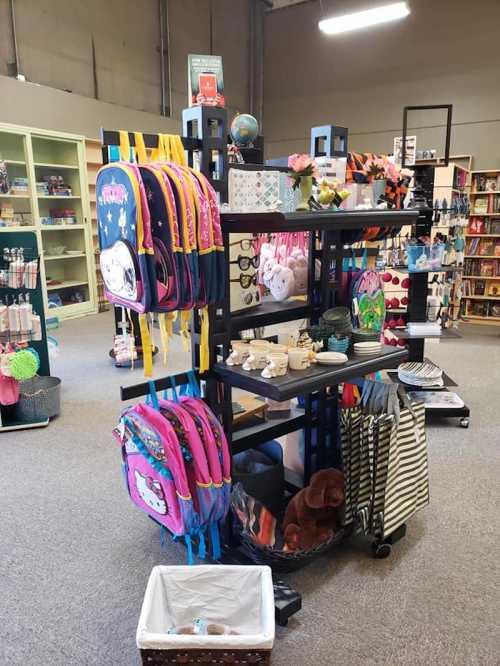 A display stand in a store featuring colorful backpacks, school supplies, and various accessories on shelves.