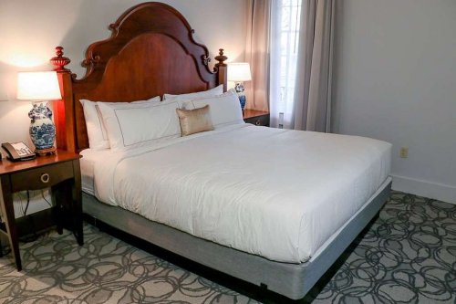 Cozy bedroom featuring a large bed, bedside tables with lamps, and a patterned carpet.