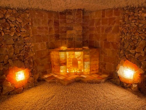 A serene salt room with glowing salt walls, a central salt bench, and soft lighting, creating a calming atmosphere.