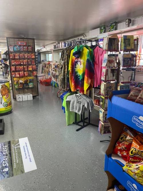 A colorful store aisle featuring snacks, clothing, and various merchandise on display.