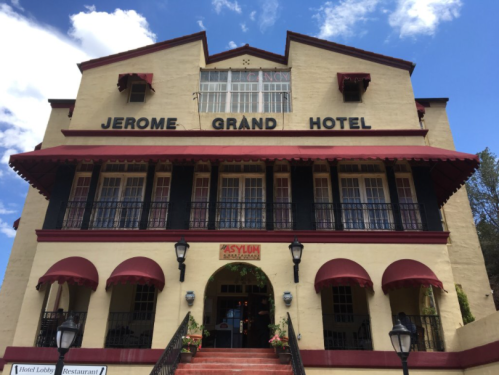 Historic Jerome Grand Hotel with red awnings and a blue sky in the background.