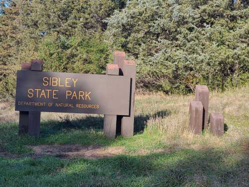 Sign for Sibley State Park, surrounded by grass and trees, indicating the Department of Natural Resources.