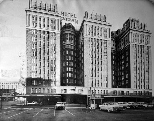 Historic black-and-white photo of the Hotel Lytle, featuring a tall, ornate building and parked vintage cars.