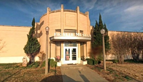Exterior view of the Pioneer Museum, featuring a round entrance and surrounding greenery.