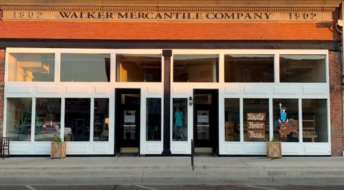 Front view of the Walker Mercantile Company building, featuring large windows and a vintage sign above the entrance.