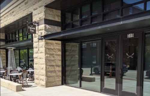 Exterior of a restaurant called "Finer Pen," featuring large glass doors and outdoor seating.