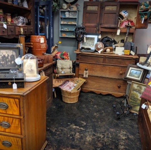 A cozy antique shop filled with vintage furniture, decor, and various collectibles on display.