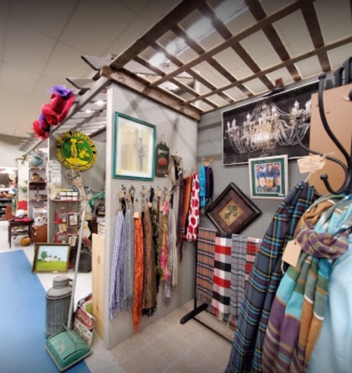 A cozy vintage shop display featuring clothing, accessories, and decorative items on walls and racks.