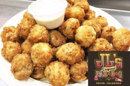 A plate of golden, crispy fried food balls served with a small cup of dipping sauce. JL's BBQ logo in the corner.
