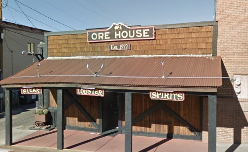 Exterior of the Ore House restaurant, featuring a wooden facade and signs for steak, lobster, and spirits. Established 1972.