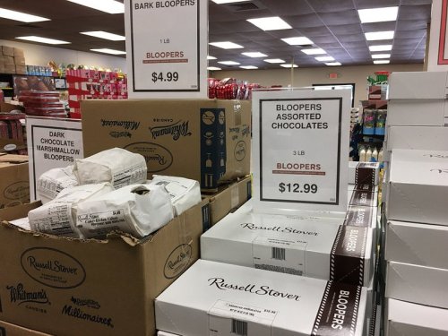 A store display featuring boxes of assorted chocolates labeled "Bloopers" and "Bark Bloopers" with price signs.