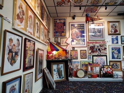 A colorful room filled with framed circus posters, vintage photos, and decorative items, creating a nostalgic atmosphere.