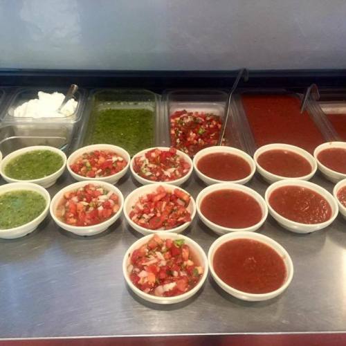 A variety of colorful salsas and sauces in bowls, arranged neatly on a counter.
