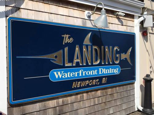 Sign for "The Landing" Waterfront Dining in Newport, RI, featuring a blue background and fish graphics.