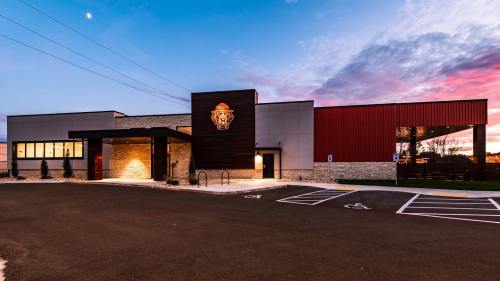 Modern building exterior with a lion emblem, featuring a mix of stone and metal, under a colorful sunset sky.