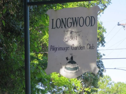 Sign for Longwood Pilgrimage Garden Club, established in 1861, surrounded by greenery.