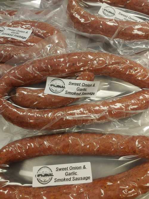 Several packages of sweet onion and garlic smoked sausage, labeled and arranged on a surface.