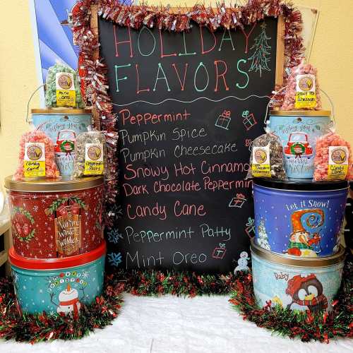 A chalkboard lists holiday flavors: Peppermint, Pumpkin Spice, Candy Cane, and more, surrounded by festive decorations.