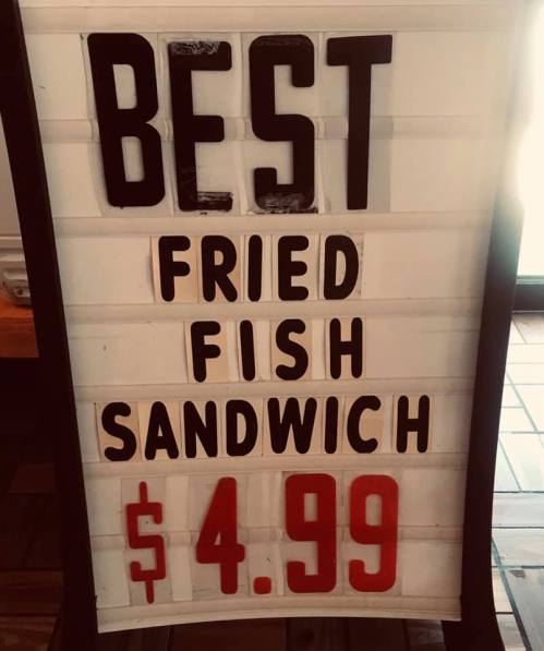 Sign advertising "Best Fried Fish Sandwich" for $4.99.