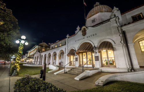 Historic building of the Guava Baths illuminated at night, featuring arched doorways and decorative architecture.