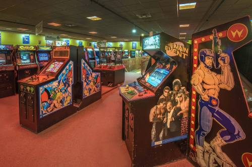 A retro arcade filled with classic game machines and colorful cabinets, creating a nostalgic gaming atmosphere.
