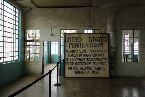 Interior of Alcatraz with a sign stating access restrictions and information about the penitentiary.