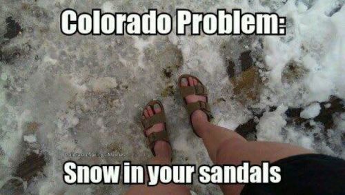 A person stands in snow wearing sandals, with the text "Colorado Problem: Snow in your sandals."