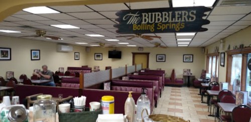 Interior of a diner named "The Bubblers," featuring booths, tables, and a welcoming atmosphere.