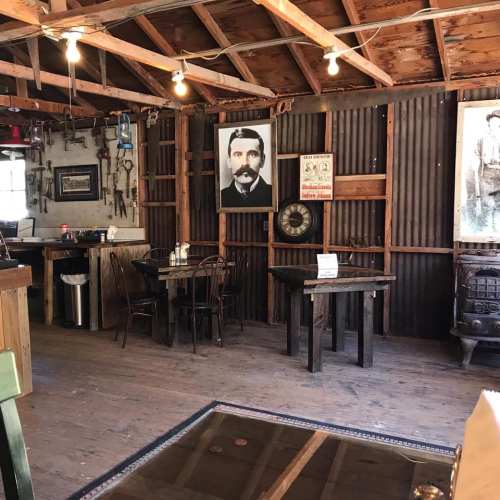 Interior of a rustic café with wooden tables, vintage photos on the walls, and a cozy atmosphere.