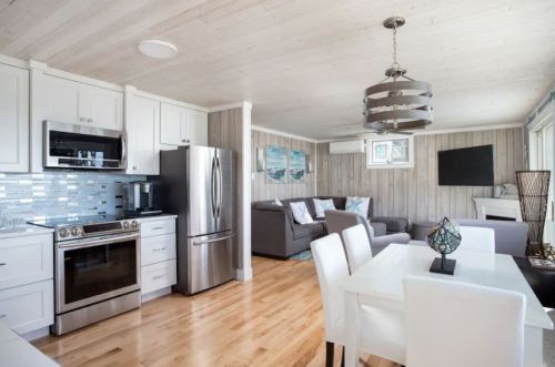 Bright, modern open-concept living space with a kitchen, dining area, and cozy seating in neutral tones.