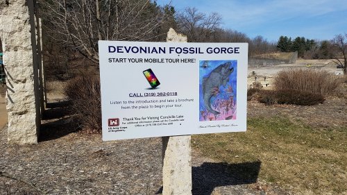 Sign for Devonian Fossil Gorge inviting visitors to start a mobile tour, with contact information and instructions.