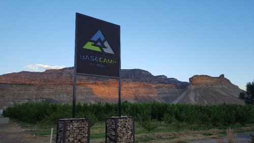 Sign for BaseCamp with mountains in the background and a clear blue sky.