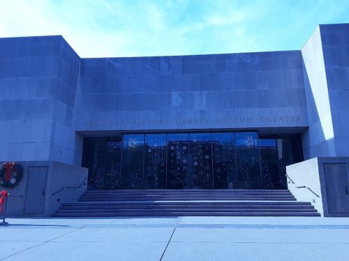 Entrance of the Archives History Library Museum Theater, featuring a modern facade and decorative elements.