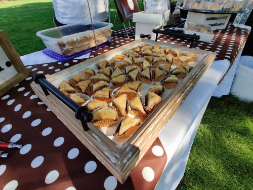 A tray of neatly arranged baklava pieces on a polka dot tablecloth at an outdoor event.