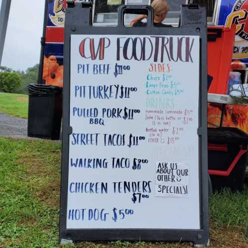 Menu board for a food truck featuring items like pit beef, pulled pork, street tacos, and drinks with prices listed.