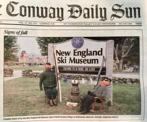A newspaper front page featuring a sign for the New England Ski Museum with scarecrow figures in autumn decor.