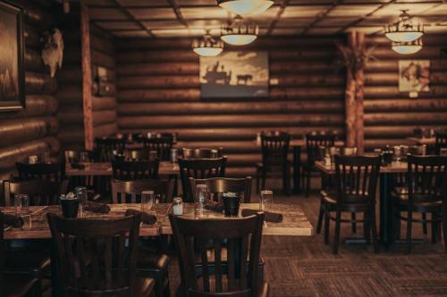 Cozy restaurant interior with wooden walls, empty tables, and rustic decor, creating a warm, inviting atmosphere.