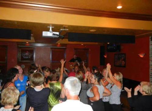 A lively crowd of people dancing and enjoying live music in a cozy venue.
