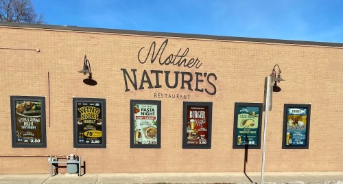 Exterior of Mother Nature's Restaurant featuring promotional signs for various themed nights.